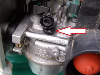 Gaźnik silnika kosiarki ze wskazaniem strzałką umiejscowienie dyszy biegu jałowego wraz z uszczelnieniami w postaci oringów