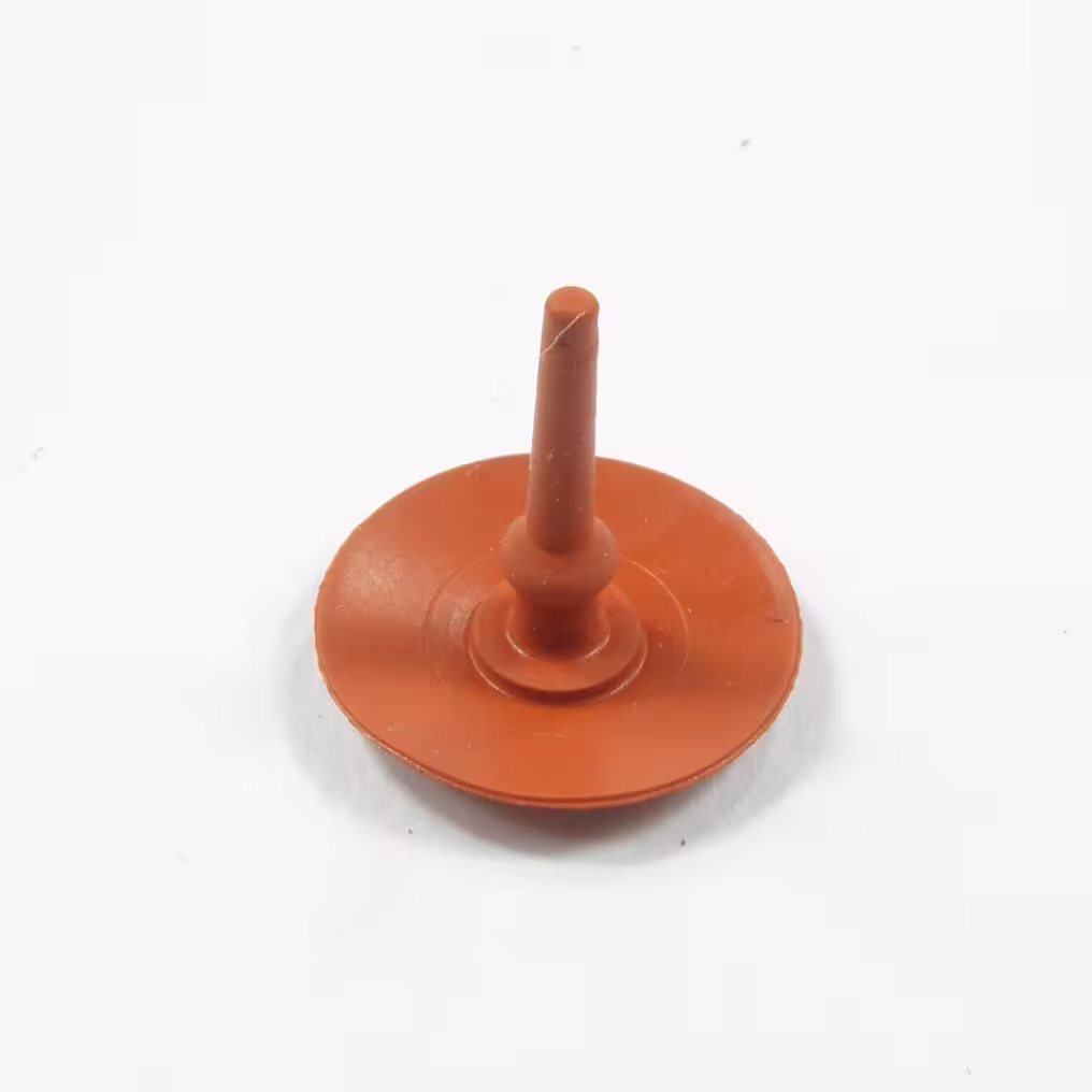 Pomarańczowy, gumowy, zawór odpowietrznika firmy STIHL, nazywany parasolowym , grzybkiem. Widok z przodu na białym tle.